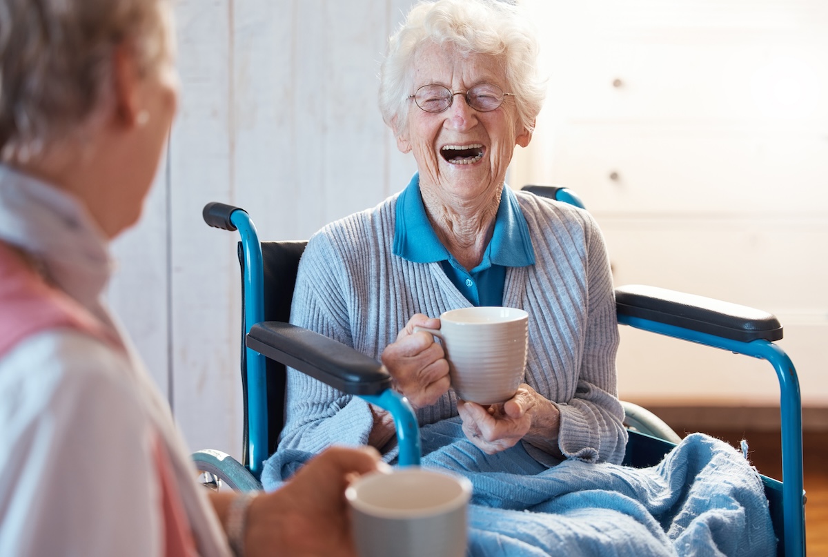 Two senior women share a chat as they receive one-on-one support in assisted living.