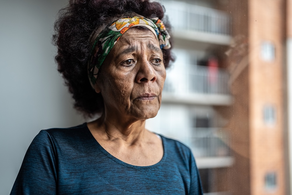 A woman with a strained expression illustrates the importance of being able to recognize pain in older adults and respond appropriately. 