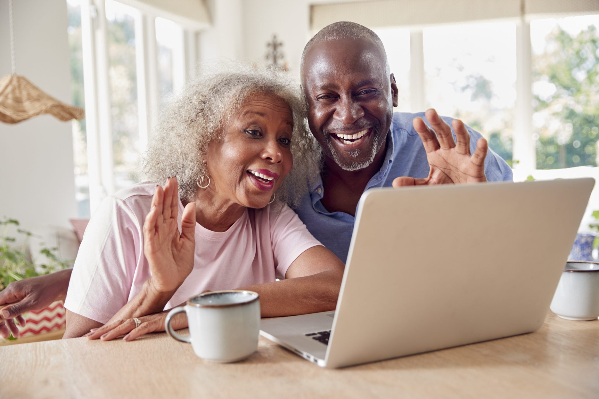 An older couple use their computer to connect with family members, highlighting how helpful technology for seniors can be when it comes to communication.