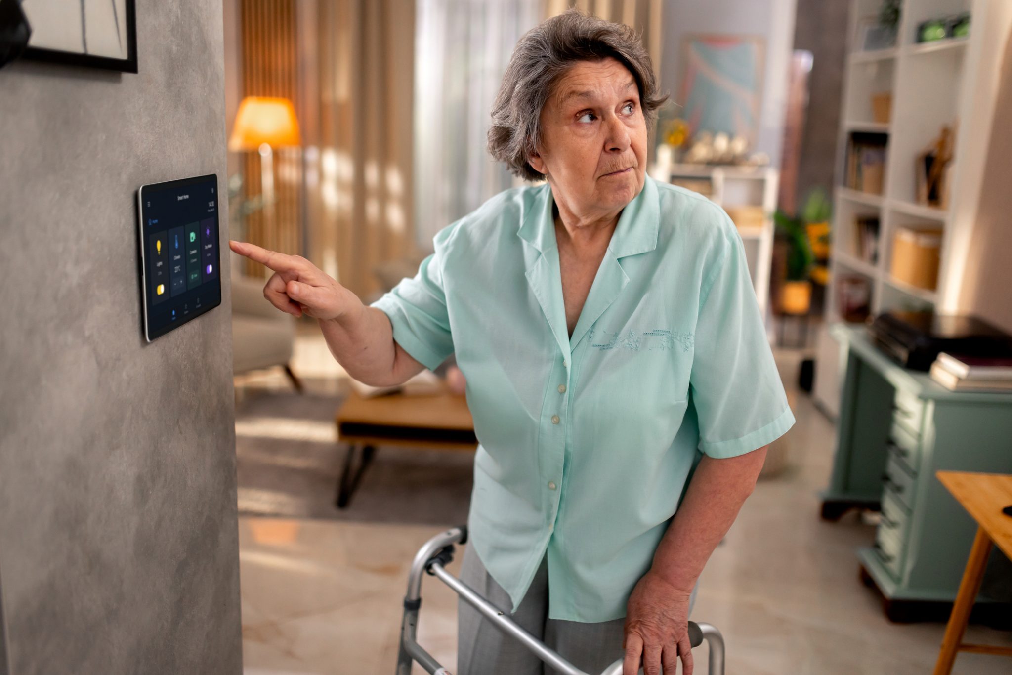 A woman adjusts a senior home safety monitoring device in her home.